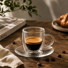 Lade das Bild in den Galerie-Viewer, Doppelwandiges Espressoglas Triest 80 ml mit Espresso auf Holztisch, daneben Croissant und Kaffeebohnen