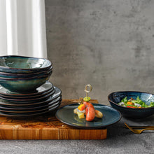 Lade das Bild in den Galerie-Viewer, Kadum Pastateller Ø 20 cm in Blau-Grün-Gold, handbemalt, auf gedecktem Tisch mit mediterraner Vorspeise und passendem Geschirr.
