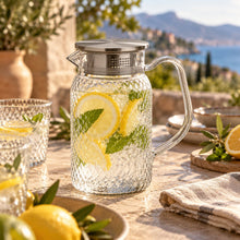 Lade das Bild in den Galerie-Viewer, OONYQ Legacy Karaffe 1000 ml – bruchsichere Karaffe aus Tritan mit Rautenmuster und Edelstahldeckel mit Zitronenlimonade auf der Terrasse