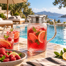 Lade das Bild in den Galerie-Viewer, OONYQ Legacy Karaffe 1000 ml – bruchsichere Karaffe aus Tritan mit Rautenmuster und Edelstahldeckel mit Himbeer-Limonade am Pool