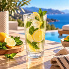Lade das Bild in den Galerie-Viewer, OONYQ Striped Longdrink 530 ml – bruchsicheres Longdrinkglas aus Tritan mit Rillenoptik mit Zitronenlimonade auf der Terrasse