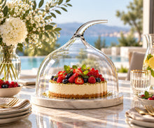 Lade das Bild in den Galerie-Viewer, OONYQ Crystal Cake Cover Ø 308 mm – bruchsichere Tortenhaube aus Tritan mit geschwungenem Griff über Beerentorte auf Marmorplatte mit Poolblick