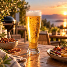 Lade das Bild in den Galerie-Viewer, OONYQ Crystal Beer 600 ml – bruchsicheres Bierglas aus Tritan mit frisch gezapftem Bier auf einer Terrasse am Meer bei Sonnenuntergang
