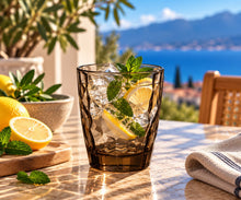 Lade das Bild in den Galerie-Viewer, OONYQ Essential Tumbler Black 300 ml – bruchsicherer Tumbler aus Tritan in Rauchglas-Optik mit Facettenschliff mit Zitronen-Minz-Drink auf der Terrasse
