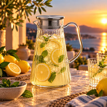 Lade das Bild in den Galerie-Viewer, OONYQ Striped Karaffe 1500 ml – bruchsichere Karaffe aus Tritan mit Rillenoptik und Edelstahldeckel mit Zitronenlimonade bei Sonnenuntergang
