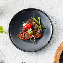Lade das Bild in den Galerie-Viewer, Schwarzer Keramik-Frühstücksteller Goma Ø 22 cm mit Steak, Tomaten und grünem Spargel, eleganter gedeckter Tisch
