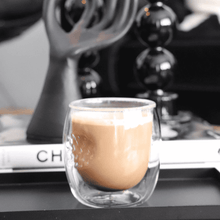 Lade das Bild in den Galerie-Viewer, Doppelwandiges Thermoglas Nizza mit Latte Macchiato vor schwarz-weißem Hintergrund
