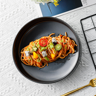 Schwarzer Keramik-Pastateller Goma Ø 23 cm mit Fuß, serviert mit Pasta und Tomatensoße
