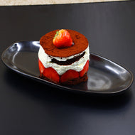 Schwarze Keramik-Servierplatte Goma, länglich, serviert mit Erdbeer-Dessert auf schwarzem Hintergrund