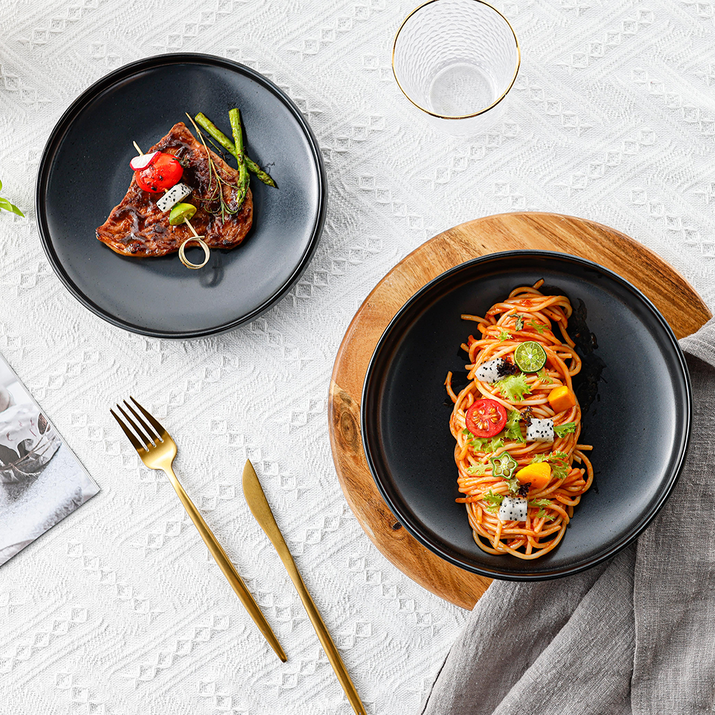 Schwarze Keramik-Speiseteller Goma Ø 25 cm, gedeckter Tisch mit Pasta und Steak, elegantes Tischarrangement